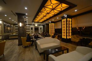 a lobby of a hotel with people sitting at tables at White Park Hotel in Sarıkamıs