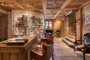 una cucina con pavimenti in legno e bancone con sedie di Hôtel Les Servages d'Armelle a Les Carroz d'Araches