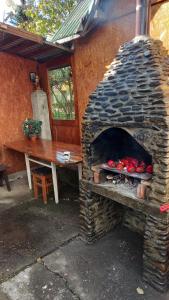 un horno de piedra con una mesa y un banco en CASA CU LAVANDĂ, en Vatra Dornei