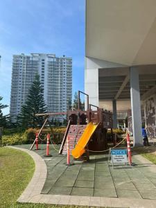 a playground with a slide in front of a building at SMDC Wind residences in Tagaytay