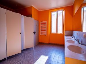 a bathroom with three sinks and orange walls at BANANA'S CAMP in Cannes