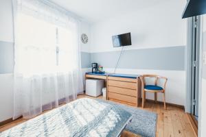 a bedroom with a desk and a chair and a window at Stral-Sund in Stralsund