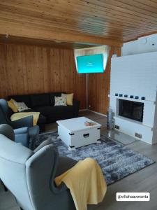 a living room with a couch and a tv at Villa Haaveranta - Cosy cabin by the lake in Rovaniemi