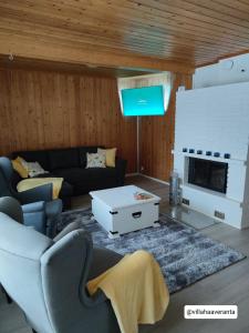 a living room with a couch and a tv at Villa Haaveranta - Private Villa by the lake in Rovaniemi