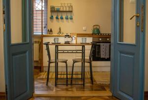 a kitchen with a table and two stools at Przemysl Old Town Style in Przemyśl
