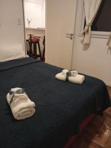 dos toallas en una cama con una manta negra en Botanico 2 ambientes en Buenos Aires