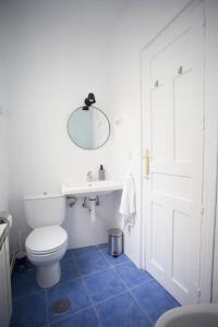 ein Badezimmer mit einem WC, einem Waschbecken und einem Spiegel in der Unterkunft Gran Via Experience in Madrid