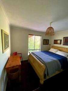 1 dormitorio con cama, mesa y ventana en The Cabin at Lake Tyers, en Lake Tyers