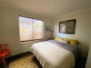 Un dormitorio con una cama grande y una ventana en The Cabin at Lake Tyers, en Lake Tyers