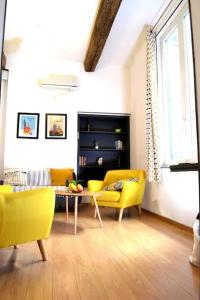 a living room with yellow chairs and a table at Apprt Top Center / 2 Chambres / 2 Salles de bain. in Montpellier