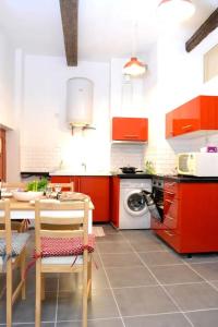 cocina con armarios rojos, mesa y sillas en Apprt Top Center / 2 Chambres / 2 Salles de bain., en Montpellier