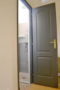 une porte donnant sur une salle de bains avec douche et une porte en verre. dans l'établissement Apprt Top Center / 2 Chambres / 2 Salles de bain., à Montpellier