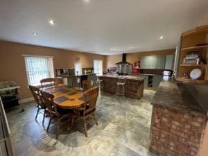a large kitchen with a wooden table and chairs at Belton House Holiday Home in Wanlockhead