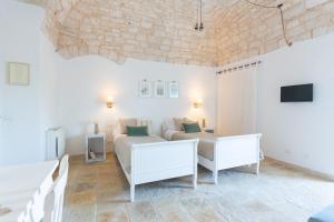 uma sala de estar com mobiliário branco e um sofá em Tenuta Pinto em Mola di Bari