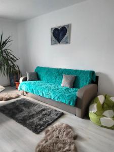 a living room with a couch with a blue blanket at Apartament Geo in Nehoiu