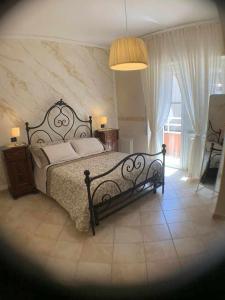 ein Schlafzimmer mit einem großen Bett und einem großen Fenster in der Unterkunft Appartamento sul porto Nettuno in Nettuno