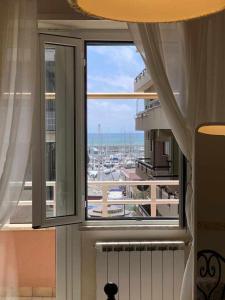 ein Fenster in einem Zimmer mit Hafenblick in der Unterkunft Appartamento sul porto Nettuno in Nettuno