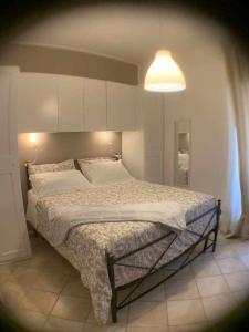 ein großes Bett in einem Schlafzimmer mit einer Lampe in der Unterkunft Appartamento sul porto Nettuno in Nettuno
