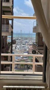 Blick auf den Hafen von einem Fenster eines Gebäudes in der Unterkunft Appartamento sul porto Nettuno in Nettuno