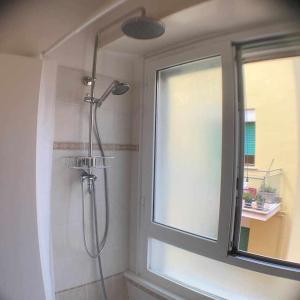 eine Dusche im Bad mit Fenster in der Unterkunft Appartamento sul porto Nettuno in Nettuno