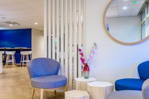 una sala d'attesa con due sedie e uno specchio di Comfort Hotel Paris Porte d'Ivry a Ivry-sur-Seine