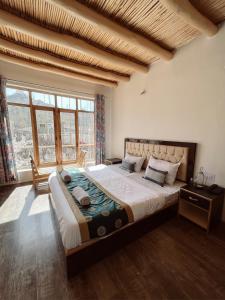 a bedroom with a large bed and a large window at zikzik holidays in Leh