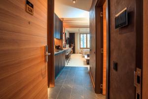 a hallway leading to a kitchen with wooden walls at Woodside Kopaonik in Kopaonik +42 photos