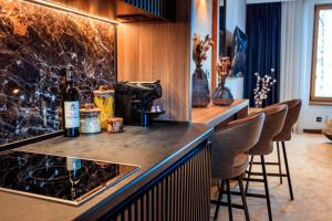 a bar with a bottle of wine and stools at Woodside Kopaonik in Kopaonik
