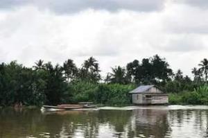 a house in the middle of a body of water at EXPRESS O 91674 Penginapan Bm Prima in Duri