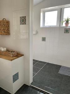 a white tiled shower with a window in a bathroom at Little Limes an Adorable little Suffolk getaway with outside space near Woodbridge in Eyke