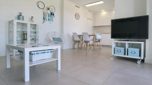 a living room with a television and a table with chairs at Panorama Beach - Blue Horizon in Torrox Costa