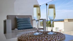 a table with two wine glasses on a table with a couch at Panorama Beach - Blue Horizon in Torrox Costa
