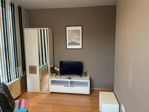 a living room with a television and a white cabinet at Apartment Maximilian in old Town in Innsbruck