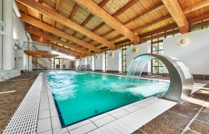a swimming pool with a waterfall in a building at Hotel zur Waldbahn in Zwiesel