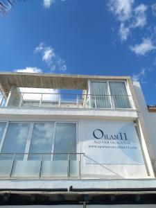 un edificio blanco con un cartel. en Apartments-OILAN11 - Estudios en primera línea de playa PEDREGALEJO, en Málaga