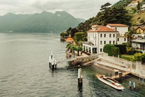 サーラ・コマチーナにあるMUSA Lago di Comoの船が水の中の桟橋に停泊