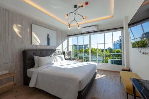 1 dormitorio con cama grande y ventana grande en R2 Hotel Chiangmai en Chiang Mai