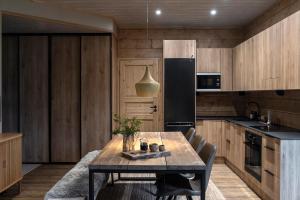 a kitchen with a table and a black refrigerator at Chalé NAAVA in Ruka