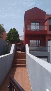 een trap naar een gebouw met een rood gebouw bij Idílico adosado en El Mocanal in Mocanal