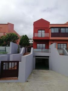 un edificio rojo con un túnel delante de él en Idílico adosado en El Mocanal, en Mocanal