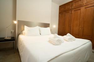 a bedroom with a large white bed with towels on it at Holiday House Penthouse in La Gomera in San Sebastián de la Gomera