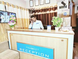 um homem a falar ao telemóvel numa recepção do monopólio do hotel em HOTEL HARMONY em Jamnagar