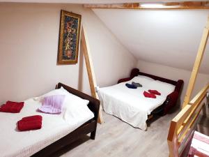 two beds in a attic room with red towels on them at Apartmani Gaga in Đenovići