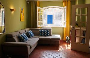 een woonkamer met een bank en een raam bij Ljmonade Hostel in Cascais