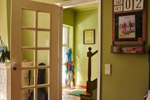 a room with green walls and a hallway with a door at Ljmonade Hostel in Cascais