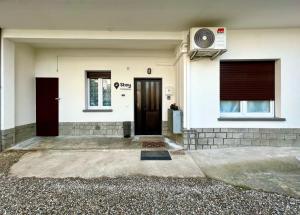 uma casa branca com uma porta preta e janelas em Stay in Malpensa em Case Nuove