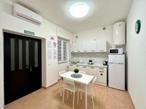 uma cozinha com uma mesa e cadeiras e um frigorífico em Stay in Malpensa em Case Nuove