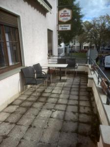 um pátio com uma mesa e cadeiras em frente a um edifício em Hotel Krone Bad Cannstatt em Stuttgart
