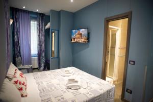 - une chambre avec un lit et un mur bleu dans l'établissement Cola Di Rienzo Suite Guest House, à Rome