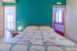 a bedroom with a large bed with a blue wall at Saija Attico in Pozzallo +19 photos
